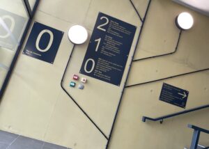 Signalétique intérieure avec plaques directionnelles par étage dans un hall d’immeuble