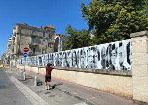 Fresque photographique en noir et blanc sur palissade à Montpellier – portraits d’habitants